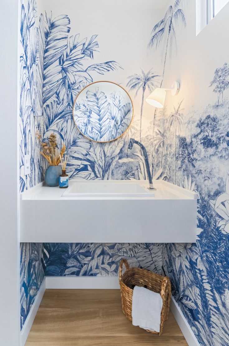 Lavabo com papel de parede azul e branco vegetação